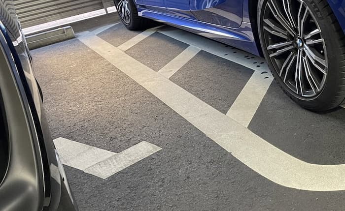 車椅子専用の駐車場の隣に車を停める時、どうかこの斜線を跨がず駐車してください。